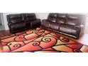 Comfortable living room setup with matching leather sofas and a patterned rug, creating a cozy and inviting space at 7844 Partridge Rd, Southport, IN 46227
