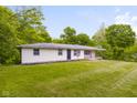 Lawn view of a single-story home with mature trees in the background at 9170 W Old Nashville Rd, Columbus, IN 47201