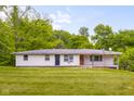Exterior front view of a ranch-style home with a well-maintained lawn and mature trees at 9170 W Old Nashville Rd, Columbus, IN 47201