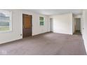 Living room with carpeted floors, door, and windows at 9170 W Old Nashville Rd, Columbus, IN 47201