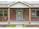 Inviting front porch with brick, windows, seating and views to the lawn at 10429 Lasalle Rd, Carmel, IN 46033