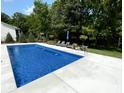 In-ground pool surrounded by lounge chairs and landscaping in this backyard oasis at 1050 Windsor Estates Ct, Westfield, IN 46074