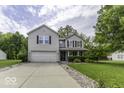 Traditional two-story home boasts a well-manicured lawn and an attached two-car garage at 1119 Albemarle Cir, Noblesville, IN 46062