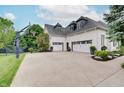 Three car garage, basketball court, and green lawn showcasing a home designed for active Gathering living at 11508 Willow Ridge Dr, Zionsville, IN 46077