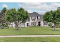 Inviting white home with well-maintained lawn and mature trees showcasing a picturesque and serene setting at 11508 Willow Ridge Dr, Zionsville, IN 46077