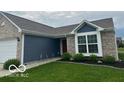 Beautifully landscaped front yard with brick and siding home featuring a two car garage and garden at 1287 Northcraft Ct, Franklin, IN 46131