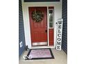 Charming red front door with welcome mat and wreath, inviting guests into a warm home at 1287 Northcraft Ct, Franklin, IN 46131