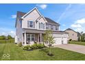 Beautiful two-story home with gray siding, a three-car garage, and a lush green lawn at 13410 Mancroft Dr, Fishers, IN 46037