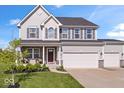 Charming two-story home featuring gray siding, a three-car garage, well-manicured lawn and stone accents at 13410 Mancroft Dr, Fishers, IN 46037