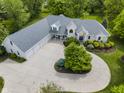 An aerial view of a sprawling property showcasing a white brick home, multi-car garage, and mature landscaping at 13909 Springmill Rd, Carmel, IN 46032
