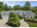 An aerial view displays a large property with mature trees, manicured gardens, and circular drive at 13909 Springmill Rd, Carmel, IN 46032