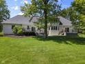 Backyard with a lush lawn, mature trees, and multiple decks accessible from the house at 13909 Springmill Rd, Carmel, IN 46032