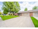 Spacious home featuring a large driveway and well-kept lawn with mature trees at 143 Asbury Dr # 86A, Anderson, IN 46013