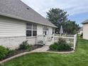 Beautiful backyard featuring a patio area with a white picket fence and lush landscaping at 1604 Stonewall Dr, Greenfield, IN 46140
