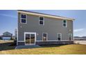 Exterior view of gray siding and a brick foundation, showing a sliding glass door to the backyard at 1614 N Clearwater Dr, Greenfield, IN 46140