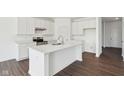 Modern kitchen with white cabinets, stainless steel appliances, and a large island with quartz countertops at 1614 N Clearwater Dr, Greenfield, IN 46140