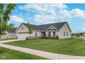 A well-maintained one-story home features a manicured lawn, landscaping, and a spacious two-car garage at 17949 Scout Ln, Westfield, IN 46074