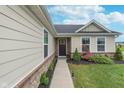 Inviting front entrance featuring a well-maintained walkway and garden bed with beautiful flowers and shrubbery at 17949 Scout Ln, Westfield, IN 46074