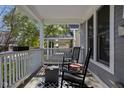 Inviting covered porch with rocking chairs and a stylish rug, perfect for relaxing and enjoying the outdoors at 2016 Central Ave, Indianapolis, IN 46202
