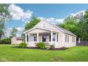 This quaint home boasts a charming front porch, attractive landscaping, and a spacious, manicured lawn at 2025 E Broadway St, Fortville, IN 46040