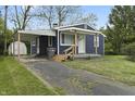 Home featuring a covered carport and a well-maintained front yard with a concrete driveway at 2344 N Leland Ave, Indianapolis, IN 46218