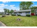 Well-manicured lawn and landscaping enhance this charming single-story home with blue shutters at 2726 Dawson St, Indianapolis, IN 46203