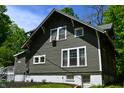 Side view of a charming home featuring detailed windows, a full basement, and manicured landscaping at 455 E Main St, Danville, IN 46122
