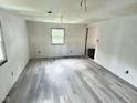 Spacious bedroom featuring new gray flooring, fresh paint, and a bright window at 4986 Adkins St, Columbus, IN 47201