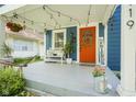 Inviting front porch decorated with string lights, a bench, and a bright orange door with seasonal decorations at 5119 Ralston Ave, Indianapolis, IN 46205