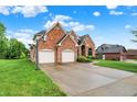 Well-maintained brick home with three-car garage, lovely landscaping, and a basketball hoop on the driveway at 5377 Crooked Stick Ct, Greenwood, IN 46142