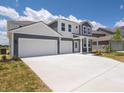 Beautiful exterior featuring a large driveway and gray siding, complemented by well-maintained landscaping at 5540 Tart Blvd, Indianapolis, IN 46239