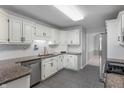 Well-maintained kitchen featuring white cabinetry, granite countertops, and stainless steel appliances at 5601 W Sun Point Dr, Muncie, IN 47304