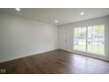 Bright living room with hardwood floors, white walls, recessed lighting, and a window overlooking the front yard at 5938 Dunseth Ct, Indianapolis, IN 46254