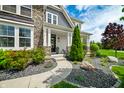 Inviting front porch with stone pillars, manicured landscaping, and a charming entrance at 5990 Hollow Ct, Bargersville, IN 46106