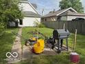 A view of the backyard with grass, lawnmowers, and other items laying in the yard at 616 N Exeter Ave, Indianapolis, IN 46222