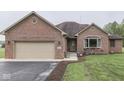A brick home with an attached garage, a well-manicured lawn and a beautiful entrance at 6494 N Baltimore Rd, Monrovia, IN 46157