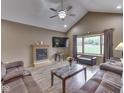 Cozy living room featuring a fireplace, ceiling fan and comfortable seating at 6494 N Baltimore Rd, Monrovia, IN 46157