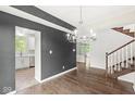 Elegant dining area with hardwood floors, modern lighting, and open access to the kitchen at 6818 Bluffridge Dr, Indianapolis, IN 46278
