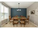 Cozy dining room with stylish chandelier, wood table, and accent wall at 7140 Lakeland Trails Blvd, Indianapolis, IN 46259