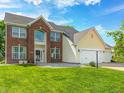 A two-story home with brick and siding, featuring a well-manicured lawn and an attached garage at 725 Bristle Lake Dr, Brownsburg, IN 46112