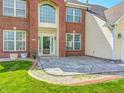 Front exterior of the home with a manicured lawn, brick accents, and front patio area at 725 Bristle Lake Dr, Brownsburg, IN 46112
