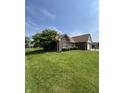 Single-Gathering home featuring brick exterior, a well-maintained lawn, and mature trees on a sunny day at 8306 Hunters Meadow Way, Indianapolis, IN 46259