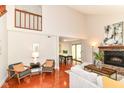 Bright living room featuring a fireplace, vaulted ceiling, wood floors, and ample seating at 8980 Cinnebar Dr, Indianapolis, IN 46268