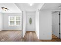 Inviting entryway with wood-look floors, white walls, and a decorative front door at 916 Ardsley Dr, Indianapolis, IN 46234