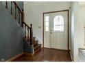Inviting entryway with hardwood floors, staircase, and a decorative glass front door at 925 Mallory Pkwy, Franklin, IN 46131