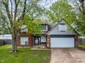 Traditional home featuring a brick facade, attached garage, and lush front yard at 925 Mallory Pkwy, Franklin, IN 46131