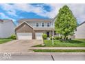 Charming two-story home boasts a well-manicured lawn, a two-car garage, and appealing curb appeal at 9712 Brooks Dr, McCordsville, IN 46055