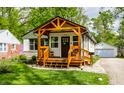 Charming exterior view of home featuring a covered porch and landscaped yard at 1240 E 56Th St, Indianapolis, IN 46220