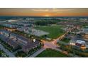 Aerial view of the townhome complex showcasing the community, green space, and sunset at 13094 Overview Dr # 5D, Fishers, IN 46037