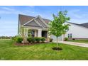 Inviting home with lush green lawn, neat landscaping, and a quaint covered porch at 16270 Northwind Ct, Westfield, IN 46074